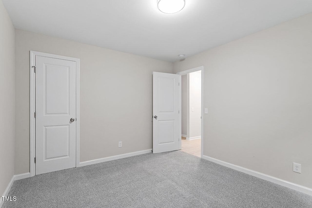 unfurnished bedroom with light colored carpet and baseboards