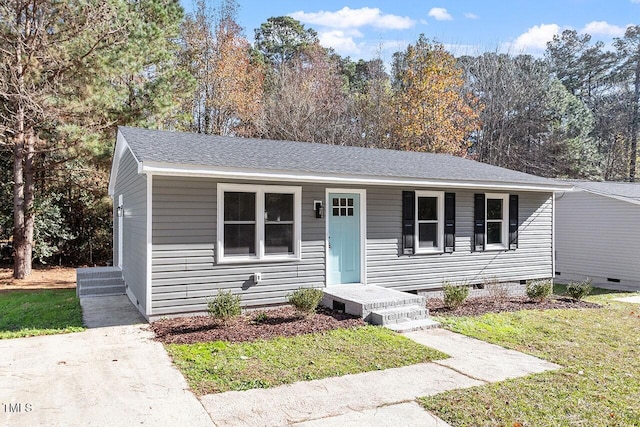 view of front of home featuring roof with shingles, crawl space, and a front yard