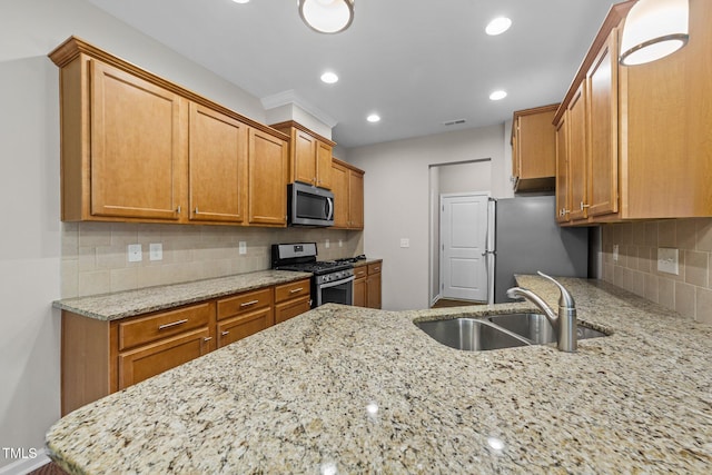 219 Zante Currant Rd, Durham, NC 27703 - kitchen with light stone counters, a sink, stainless steel appliances, brown cabinets, and backsplash