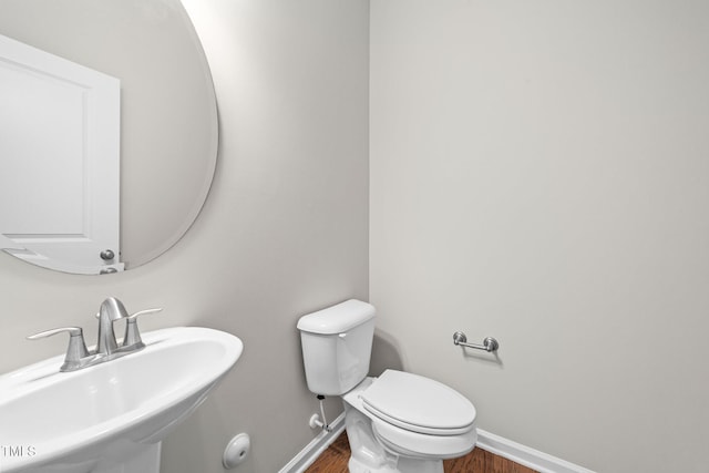 219 Zante Currant Rd, Durham, NC 27703 - half bathroom with toilet, wood finished floors, a sink, and baseboards