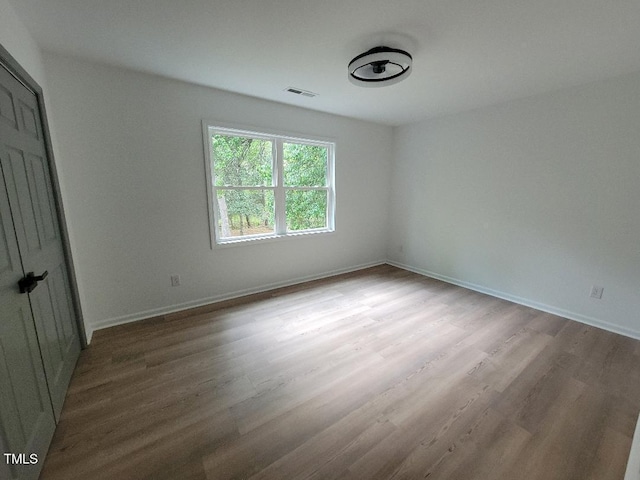 unfurnished bedroom with wood finished floors and baseboards