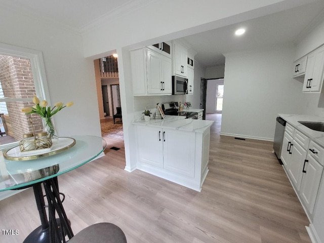 kitchen with stainless steel appliances, crown molding, white cabinetry, light wood finished floors, and light stone counters