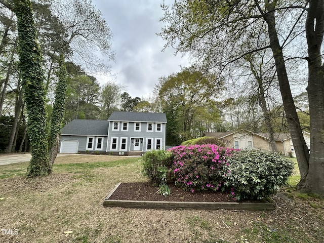 rear view of property with a garage and a yard