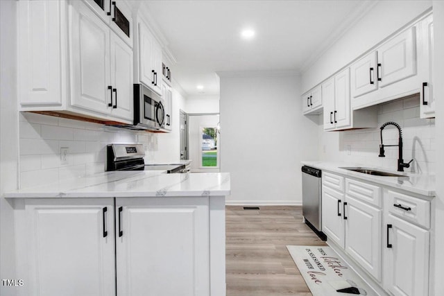 1506 Darby Rd, Goldsboro, NC 27534 - kitchen with stainless steel appliances, white cabinets, crown molding, decorative backsplash, and a peninsula