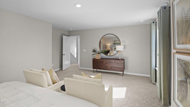 bedroom with light colored carpet and baseboards
