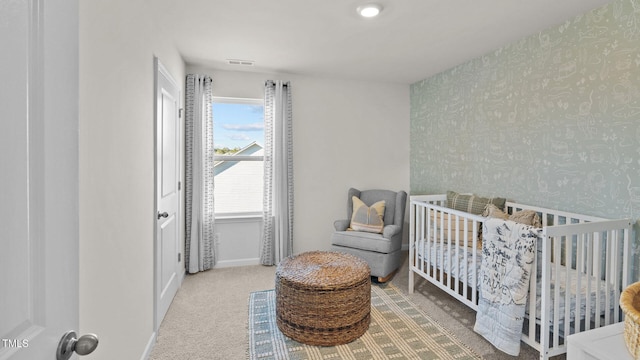 carpeted bedroom with visible vents, baseboards, wallpapered walls, and a nursery area