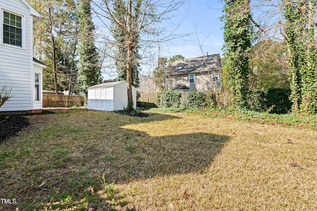 view of yard featuring a storage shed, an outbuilding, and fence