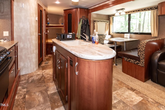142 Blackhawk Dr, Louisburg, NC 27549 - kitchen featuring a sink, stone finish floor, stove, and a center island with sink