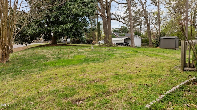view of yard with a carport, an outbuilding, and a shed