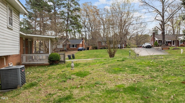 view of yard featuring covered porch and central air condition unit
