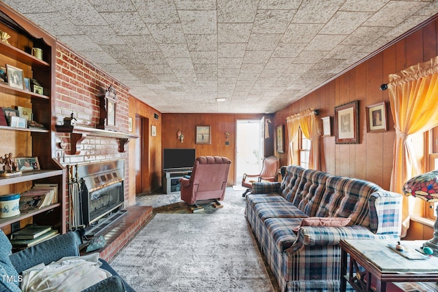 carpeted living area with wooden walls and a brick fireplace