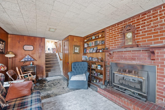 living area with wood walls, stairway, carpet flooring, and a fireplace