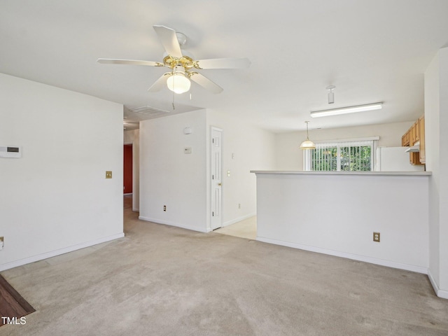 unfurnished room featuring light carpet, a ceiling fan, and baseboards