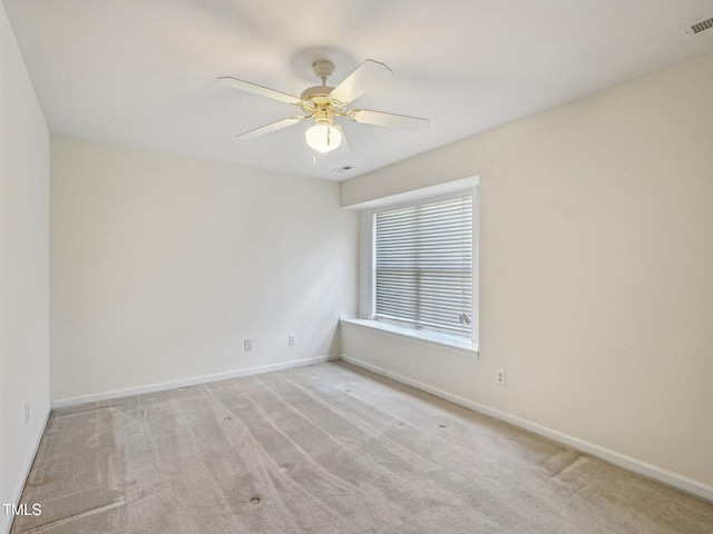 unfurnished room featuring light colored carpet, baseboards, and a ceiling fan