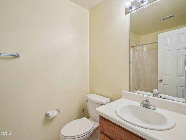 bathroom featuring toilet, vanity, and a shower with shower curtain