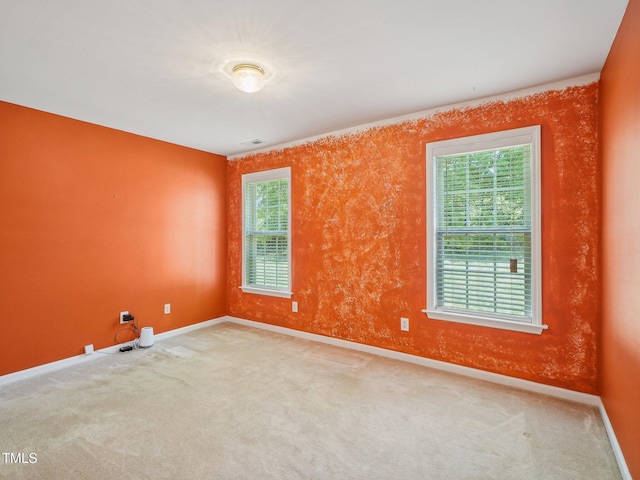 carpeted spare room featuring baseboards