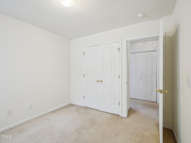 unfurnished bedroom with light carpet and baseboards