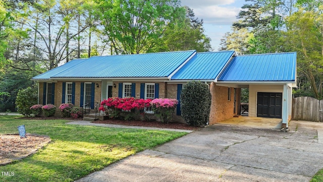 ranch-style home with driveway, a front lawn, an attached carport, brick siding, and fence