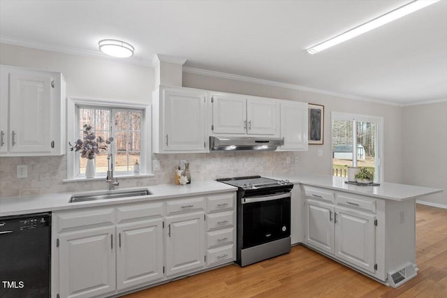 kitchen featuring a peninsula, stainless steel electric range oven, under cabinet range hood, dishwasher, and a sink