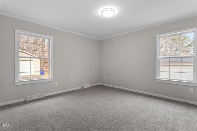 carpeted empty room with visible vents, baseboards, and ornamental molding