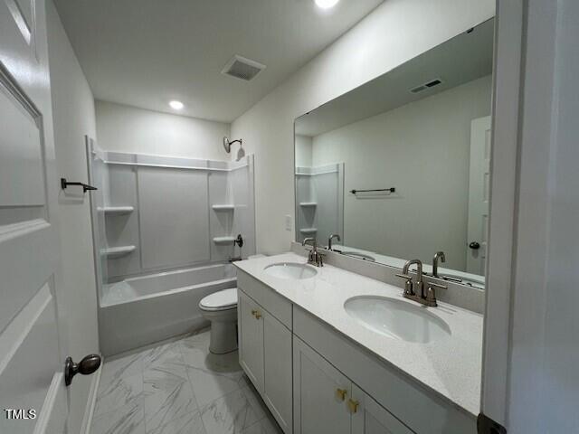 bathroom featuring a sink, toilet, shower / tub combination, and marble finish floor