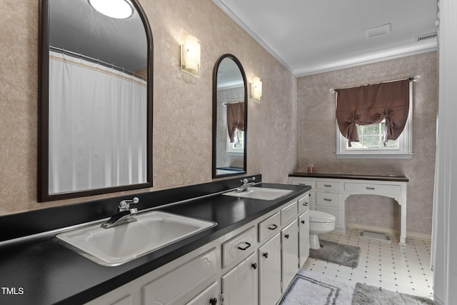 bathroom featuring toilet, double vanity, ornamental molding, a textured wall, and tile patterned floors