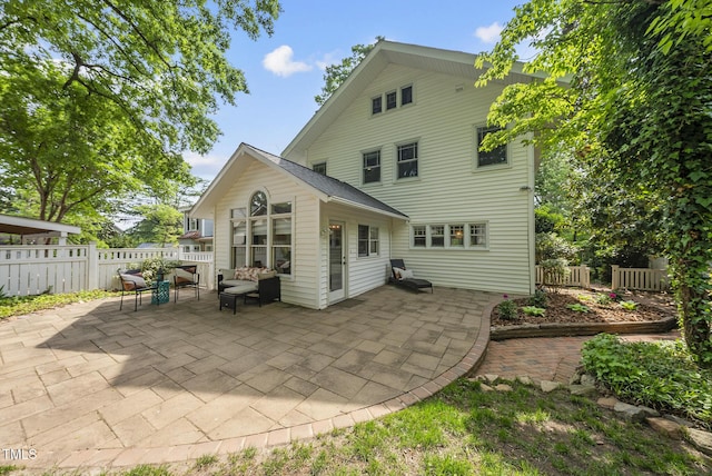 rear view of property with fence and a patio area