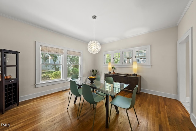 dining area with crown molding, baseboards, and wood finished floors