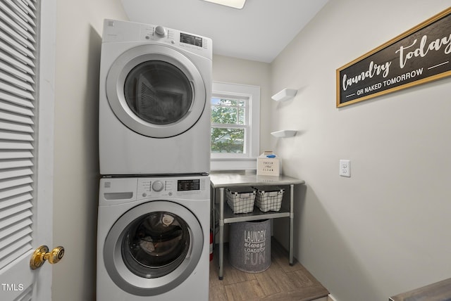 laundry room featuring stacked washer / drying machine and laundry area