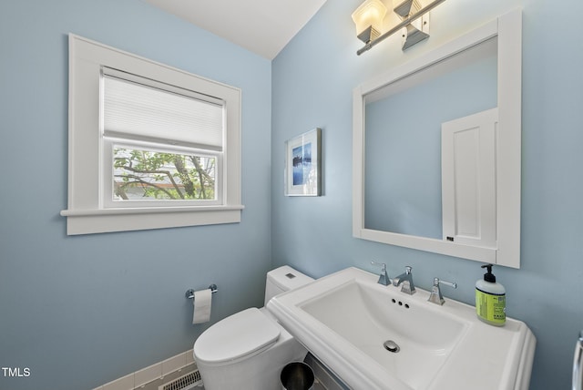 bathroom with toilet, visible vents, and a sink