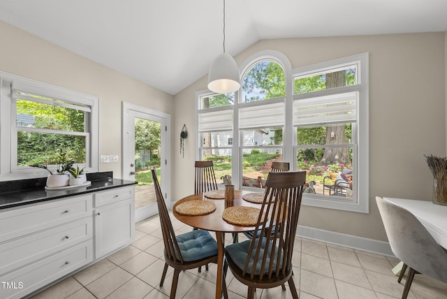 dining space with baseboards, light tile patterned floors, vaulted ceiling, and a wealth of natural light