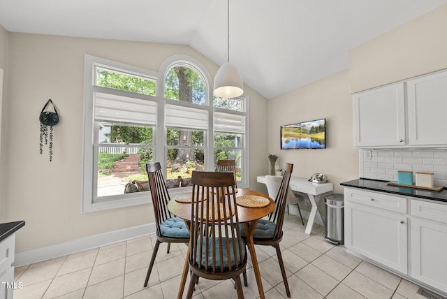 dining room with light tile patterned flooring, baseboards, vaulted ceiling, and visible vents