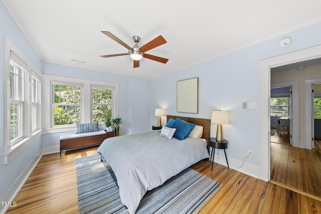 bedroom with baseboards, multiple windows, and ornamental molding