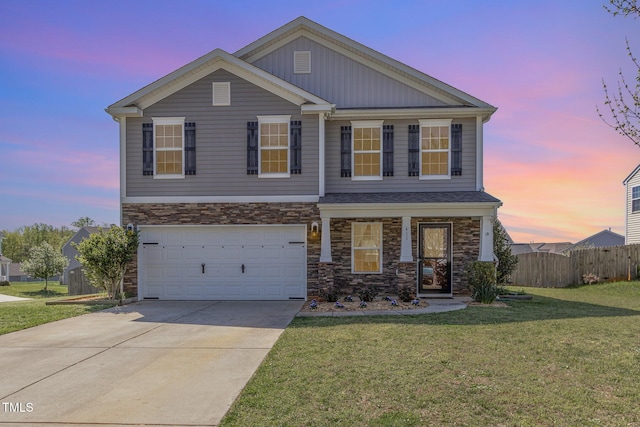 view of front of property featuring a garage, a lawn, stone siding, fence, and driveway