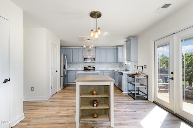 kitchen with gray cabinets, light countertops, appliances with stainless steel finishes, and open shelves