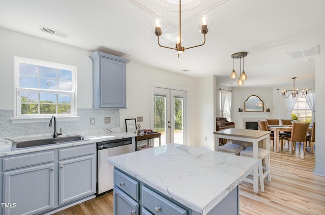 kitchen with a chandelier, visible vents, a sink, and dishwashing machine
