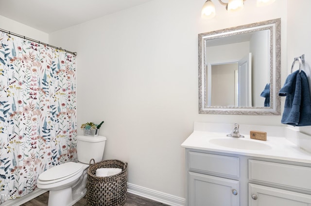 bathroom featuring baseboards, a shower with curtain, toilet, vanity, and wood finished floors