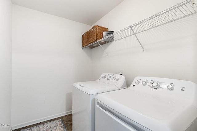 clothes washing area featuring washing machine and dryer, laundry area, and baseboards