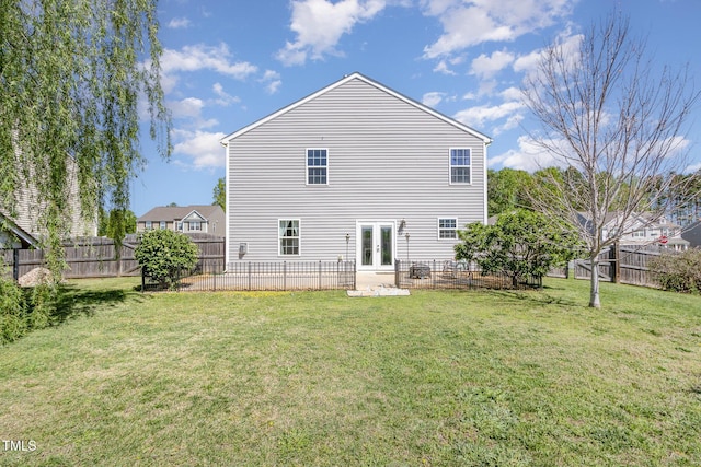 back of house featuring a patio, french doors, a fenced backyard, and a lawn