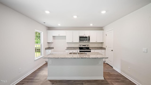 kitchen with a sink, appliances with stainless steel finishes, white cabinetry, and dark wood finished floors