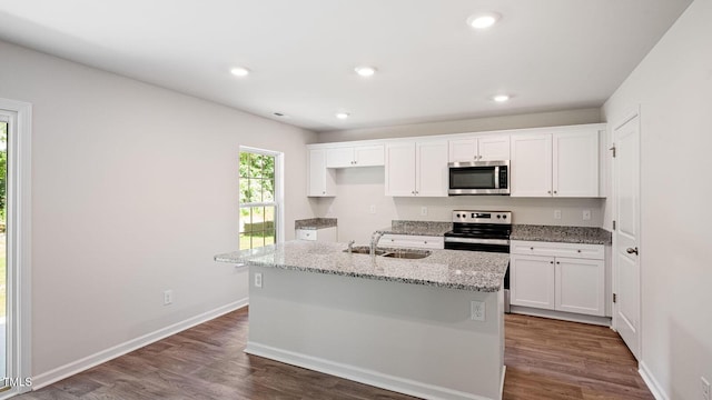 kitchen with appliances with stainless steel finishes, recessed lighting, white cabinetry, dark wood finished floors, and a sink