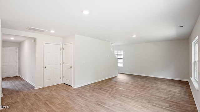 spare room featuring baseboards, light wood-type flooring, and recessed lighting