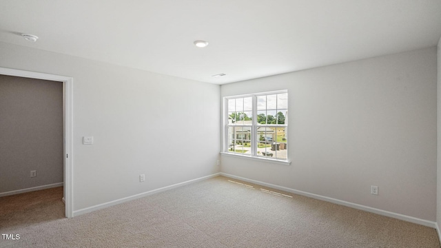 carpeted spare room with baseboards