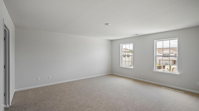spare room with carpet and baseboards