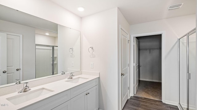 bathroom featuring a sink, visible vents, and a shower stall