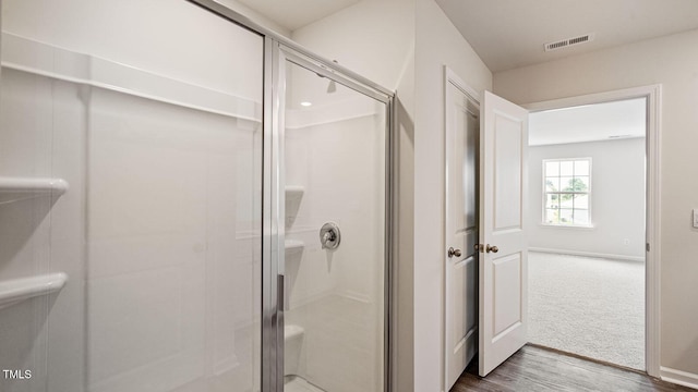 full bathroom with a shower stall, visible vents, baseboards, and wood finished floors