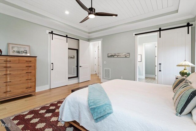 749 Golfers Vw, Pittsboro, NC 27312 - bedroom with visible vents, wooden ceiling, a barn door, a tray ceiling, and light wood finished floors