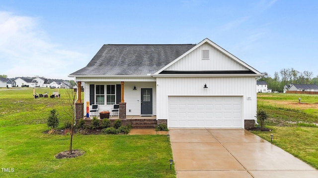 295 Springtooth Dr, Zebulon, NC 27597 - view of front facade featuring roof with shingles, driveway, an attached garage, a front yard, and covered porch