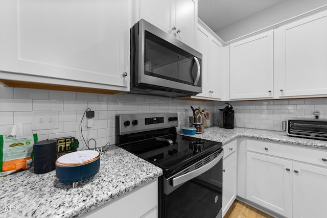 295 Springtooth Dr, Zebulon, NC 27597 - kitchen with tasteful backsplash, white cabinetry, stainless steel microwave, range with electric cooktop, and a toaster