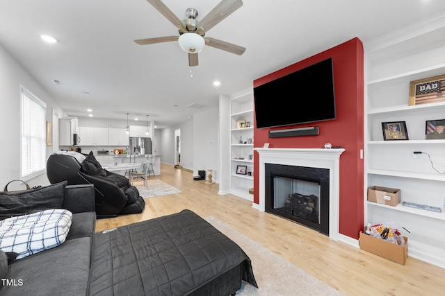 295 Springtooth Dr, Zebulon, NC 27597 - living area with baseboards, light wood-type flooring, built in features, a fireplace, and a ceiling fan